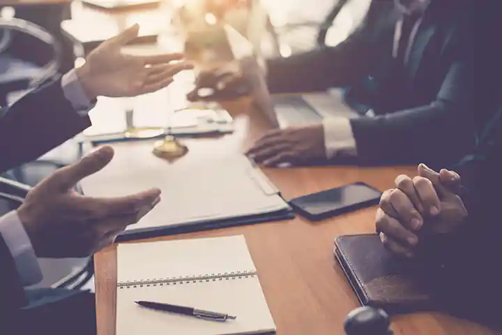 人们坐在会议桌旁听演讲